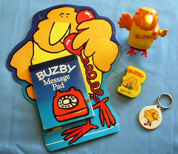 A picture of several Buzby items including a memo pad, eraser, key ring and wind up toy